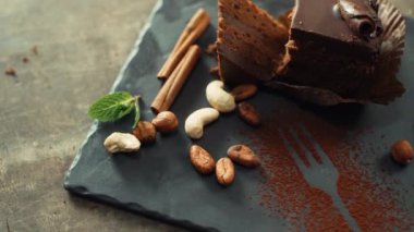 Cevizli çikolatalı pasta, tarçın ve kakao çekirdeği tabakta..