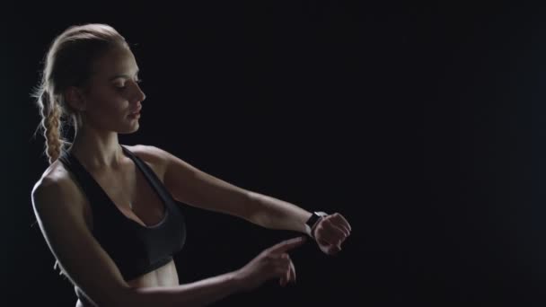 Retrato de mujer fitness buscando resultados animados en el monitor de frecuencia cardíaca . — Vídeos de Stock