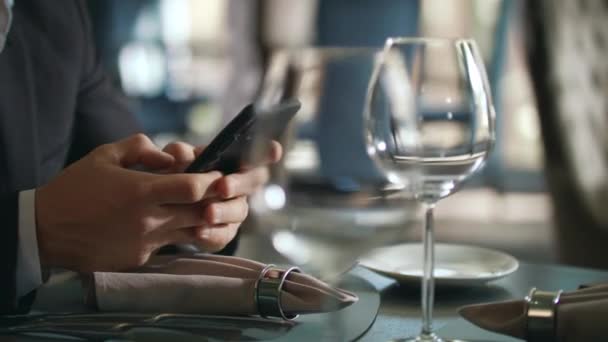 Mani maschili digitando telefono al tavolo del ristorante. Uomo d'affari utilizzando smartphone — Video Stock