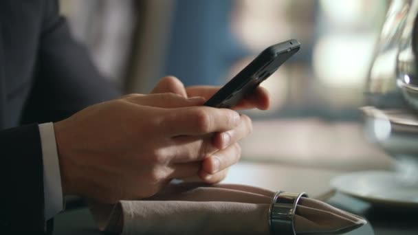 Manos masculinas usando smartphone en el restaurante. Empresario usando teléfono móvil — Vídeo de stock