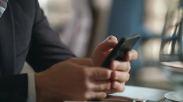 Взрослый бизнесмен, использующий смартфон для работы за ресторанным столом на бизнес-ланче — стоковое видео