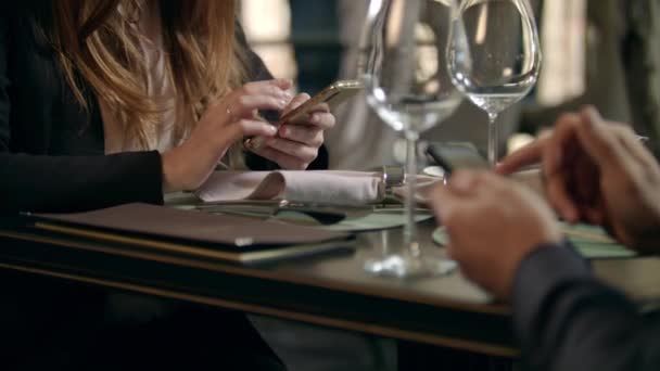 Mužské a ženské ruce používají telefon v restauraci. Pár rukou psaní telefon — Stock video