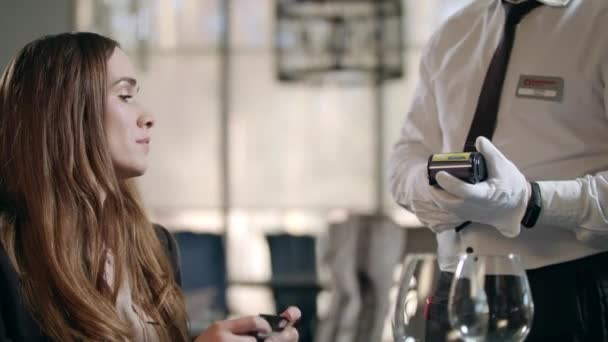 Деловая женщина, использующая банковскую карту для оплаты в ресторане — стоковое видео