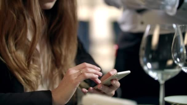 Las manos femeninas pagan la cuenta por teléfono móvil en el restaurante. Pago móvil en la cafetería — Vídeo de stock