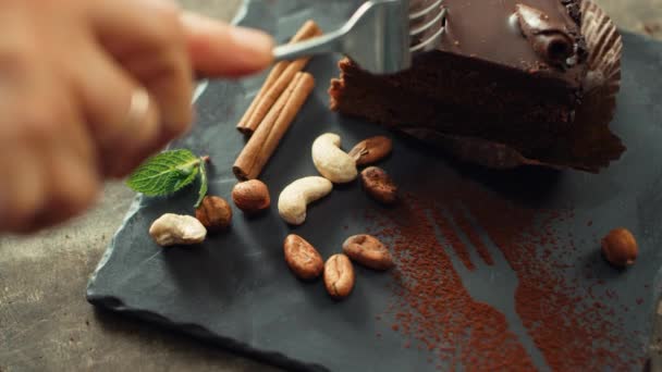 Primer plano humano corte a mano pastel de chocolate en cámara lenta . — Vídeos de Stock