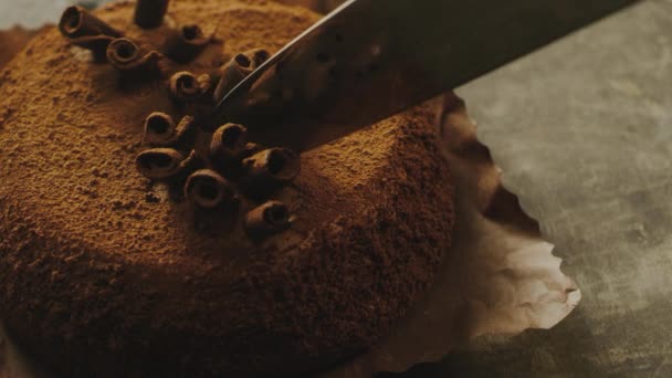 천천히 움직 이는 초콜릿 조각으로 날카로운 칼로 케이크를 자르는 일을 마무리 한다. — 비디오