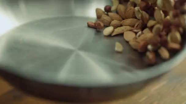 Mezcla de primer plano de nueces que se lanzan en la sartén en cámara lenta . — Vídeo de stock