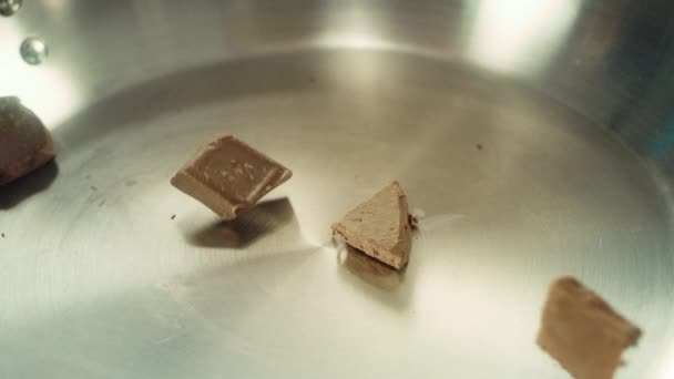 Pedaços de perto de chocolate caindo em uma panela de metal em câmera lenta . — Vídeo de Stock