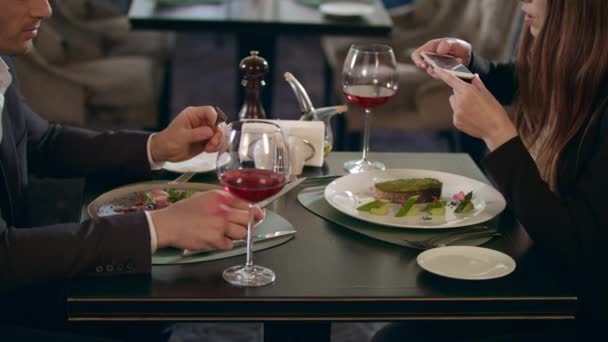 Mujer de negocios fotografiando comida en un smartphone en un restaurante — Vídeo de stock