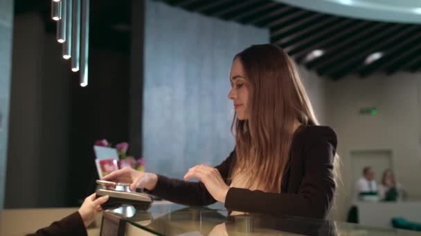 Business woman using mobile phone for contactless payment on hotel reception — Stock Video