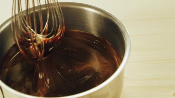 Close up of melted chocolate mixing with whisk in slow motion — ストック動画