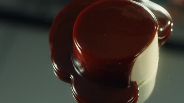Donkere chocoladestroom verspreidt zich over het oppervlak van cake. — Stockvideo