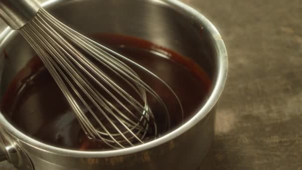 Closeup metal whisk putting into melted chocolate in slow motion. — Stock video