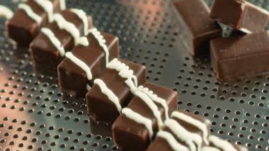 Erimiş beyaz jöle siyah çikolata şekerlerinin üzerine dökülüyor.