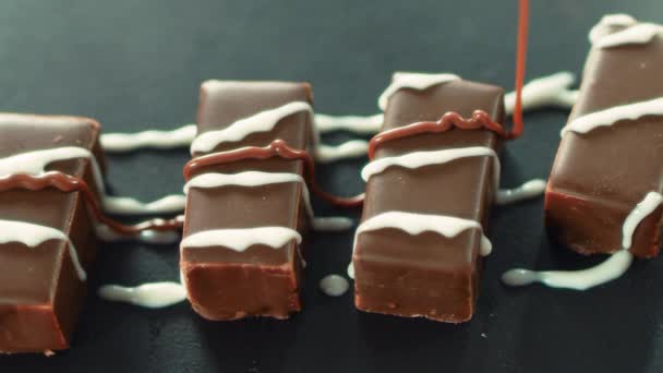 Closeup caramelo quente derramando em doces de chocolate em câmera lenta — Vídeo de Stock