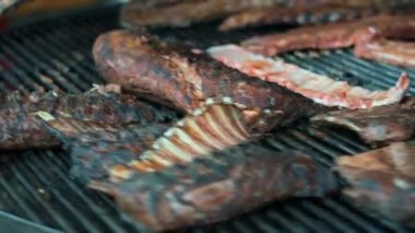 Yakındaki adam ızgarada kuzu pirzolası pişiriyor. Adam eti kızartıyor..