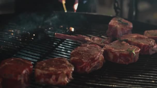 Closeup man handen koken vlees buiten. Chef zet rundvlees ribben op grill — Stockvideo