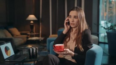 İş kadını otel odasındaki telefonu arıyor. Cep telefonu kullanan ciddi bir kadın.