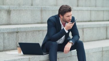 Şehirdeki iş adamı hoparlörden konuşuyor. Cep telefonu kullanan adam