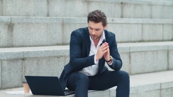 Επιχειρηματίας δακτυλογραφεί στο φορητό υπολογιστή στο δρόμο. Ο κουστουμάτος δουλεύει έξω από το γραφείο — Αρχείο Βίντεο