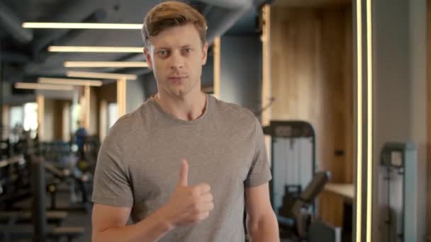 Zelfverzekerde fitnessman met duim omhoog in de sportclub. Sportman in de sportschool — Stockvideo