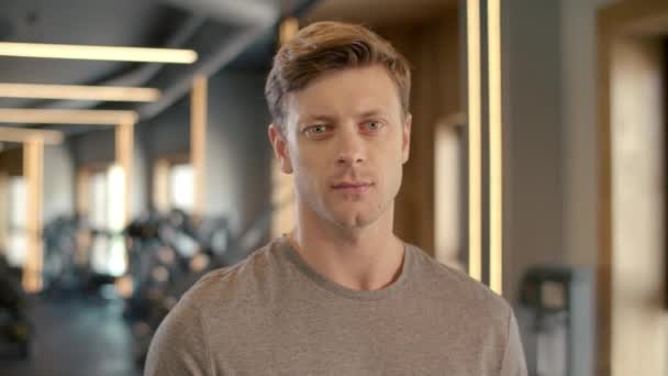 Spor salonundaki yakışıklı vücut geliştiricinin portresi. Sporcu fitness merkezinde duruyor. — Stok video