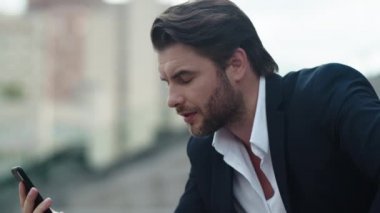 İş adamı akıllı telefondan görüntülü konuşma yapıyor. Sokakta telefon kullanan erkek çalışan.