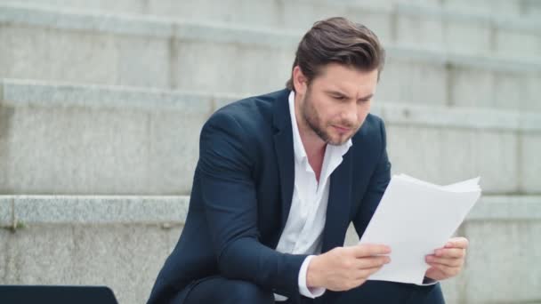 Hombre de negocios trabajando con documentos en la calle. Empresario mirando gráficos — Vídeos de Stock