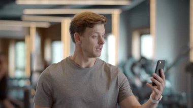 Spor salonundaki neşeli sporcunun selamı var. Gülümseyen sporcunun video çağrısı var