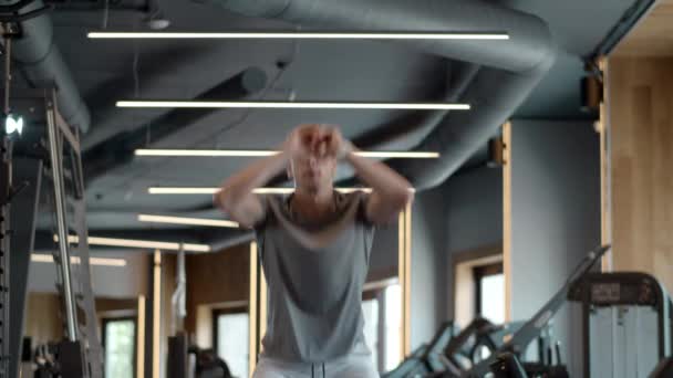 Sportsmannen hoppar på gymmet. Fokuserad kroppsbyggare gör knäböj i gymmet — Stockvideo