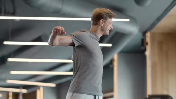 En seriös träningsman som värmer upp på gymmet. Strongman gör övningar i idrott klubb — Stockvideo