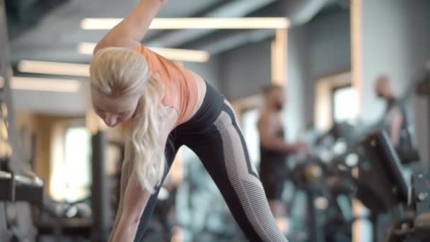 Atleta energética entrenando en el gimnasio. Mujer de fitness haciendo inclinaciones en el club deportivo — Vídeo de stock