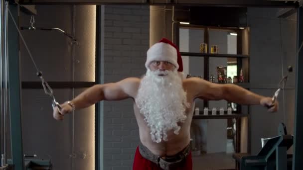 Hezoun Santa dělá v tělocvičně bicepsy. Sportovní trénink ve sportovním klubu — Stock video