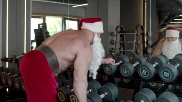 In der Turnhalle bastelt der Weihnachtsmann Hantelstangen. Sportlertraining im Sportverein — Stockvideo