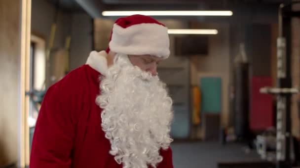 Serieuze kerstman die in de sportschool loopt. Sportman die zich uitkleedt in de sportclub — Stockvideo