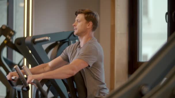 Stark kroppsbyggare gör biceps lockar i sportklubben. Sportmansträning på gym. — Stockvideo