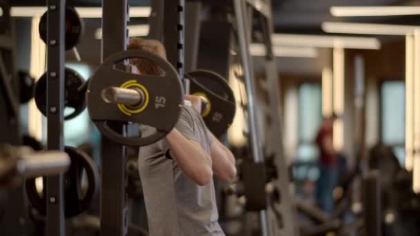 Entrenamiento de musculación enérgico hombre en el gimnasio. Ejercicio de fitness en club deportivo — Vídeos de Stock