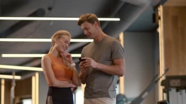 Güzel, formda bir çift spor salonunda flört ediyor. Spor kulübünde telefon numarası yazan formda bir adam.
