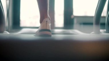 Spor kulübünde trademill 'de koşan insan ayaklarının arkası. Yakından sporcu bacakları.