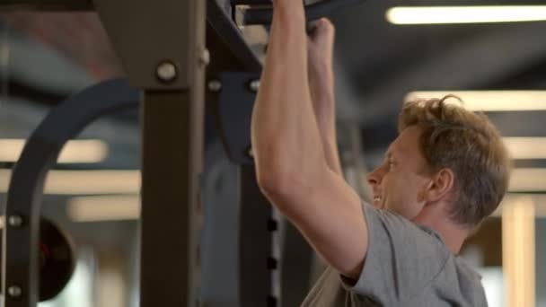 Atleta masculino agresivo haciendo chinups en el club deportivo. Entrenamiento de hombre en forma en el gimnasio — Vídeos de Stock