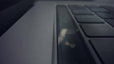 Erkek eli dizüstü bilgisayarda dokunma çubuğu kullanıyor. Erkek parmakları dizüstü bilgisayardaki dokunmatik tuşlara basıyor