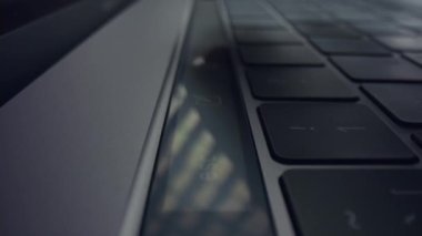 Erkek parmakları dizüstü bilgisayardaki dokunmatik tuşlara basıyor. Erkek eli laptopta dokunmatik çubuğu kullanıyor.
