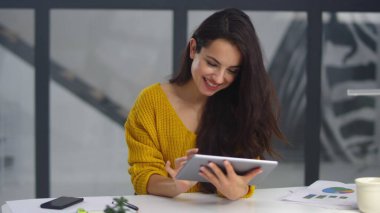 Smiling business woman surfing internet on pad. Sexy girl touching pad screen