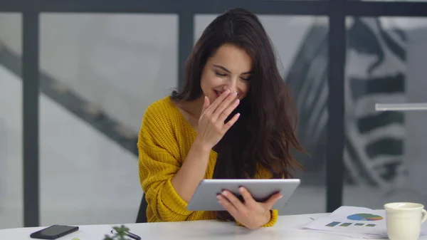 Cheerful business woman laughing with pad. Pretty woman getting funny message — Stockfoto