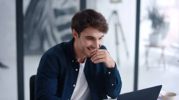 Businessman looking financial charts on notebook. Cheerful guy analyzing charts