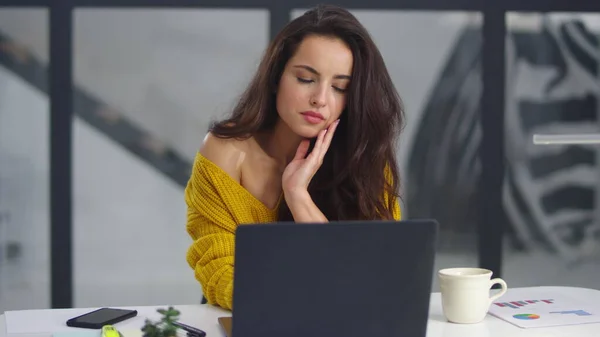 Müde Geschäftsfrau streckt die Arme nach innen. Überarbeitetes Mädchen gähnt neben Laptop — Stockfoto