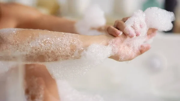 Unrecognized woman washing body with foam at bath. Woman hands touching skin — Stock Photo, Image