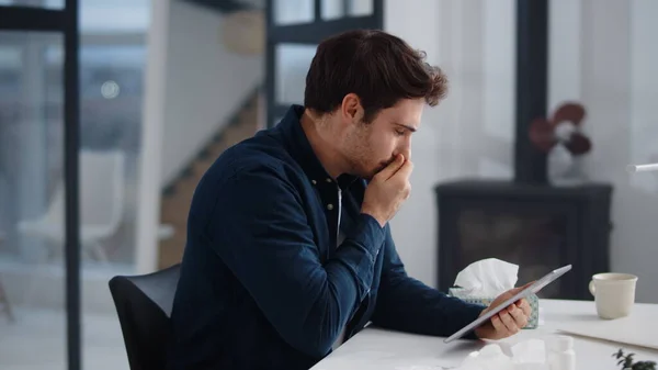 Sick business man getting flu in office. Ill man sneezing near laptop indoor. — Stockfoto