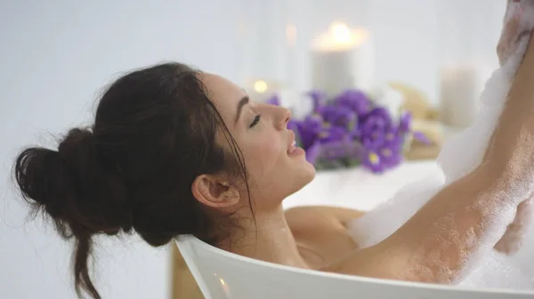 Närbild brunett kvinna tvätta händerna med skum. Elegant flicka avkopplande i badet — Stockfoto