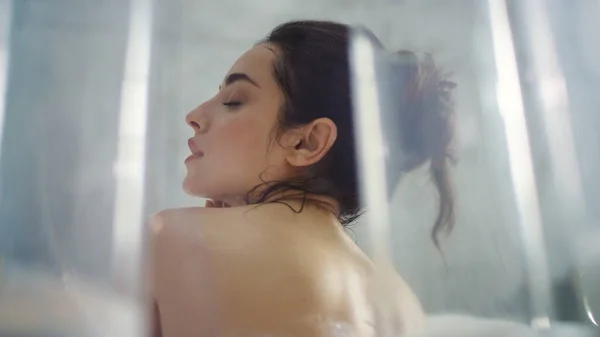 Avslappnad kvinna tvättar nacken i badkaret. Närbild het kvinna massera kroppen vid bad. — Stockfoto